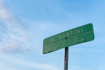 Close-up photo of the kartini street sign set against a clear blue sky