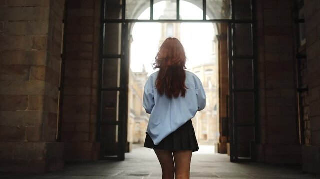 Beautiful girl student enters a bright future, university doors, admission and education, courses, lessons, recess, student life, knowledge, girl with notebooks in hands, confident, intelligence