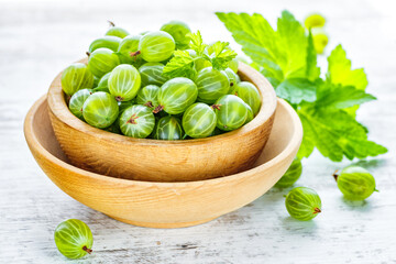 Green Organic Berries Gooseberries.Green gooseberries in a wooden bowl.Gooseberries on the wooden table. Harvest concept. Vegetarian food.