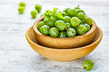 Green Organic Berries Gooseberries.Green gooseberries in a wooden bowl.Gooseberries on the wooden table. Harvest concept. Vegetarian food.