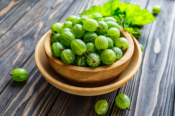 Green Organic Berries Gooseberries.Green gooseberries in a wooden bowl.Gooseberries on the wooden table. Harvest concept. Vegetarian food.
