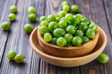 Green Organic Berries Gooseberries.Green gooseberries in a wooden bowl.Gooseberries on the wooden table. Harvest concept. Vegetarian food.
