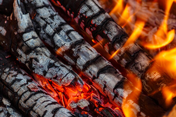 Red hot charcoal and a flame of fire.Close-up of fire, glowing charcoal and hot embers. The texture of flaming burning firewood.