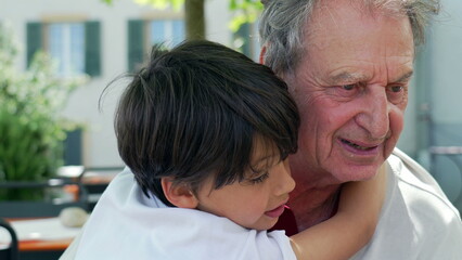 Young boy affectionately hugs his elderly grandfather outdoors, sharing a moment of closeness and love, tender expression. intergenerational connection and family bonds