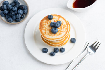 Small crepes or pancakes with blueberries, sweet dessert for breakfast