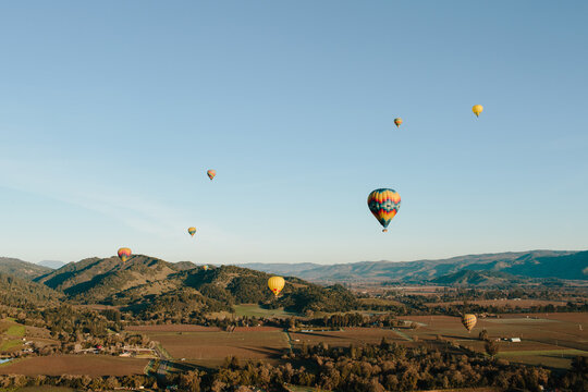 Hot air balloons and fields or hills