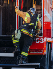 Group of fire men in uniform during fire fighting operation in the city streets, firefighters with...