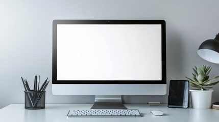 Fototapeta premium A modern minimalist workspace with a blank computer screen, keyboard, mouse, and a smartphone.