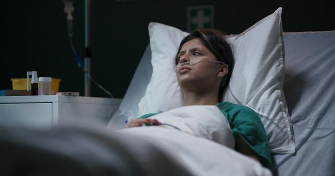 Young female patient with migraine in hospital ward recovers after hard accident.