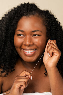 Black Woman Smiles While Holding A Piece Of Floss