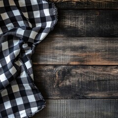 Obraz premium A black and white checkered cloth draped over a rustic wooden surface.