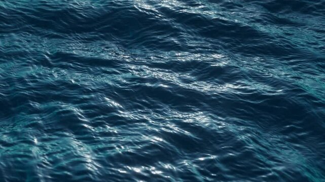 3d looping animation of a deep blue sea. Tranquil water surface with gentle ripples catching the light, conveying a sense of calm and depth. Gentle ripples on surface of the ocean