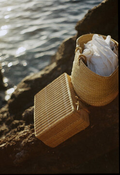 Wicker Suitcase And Basket By Sea