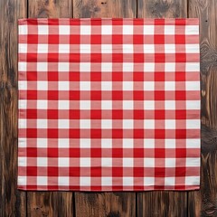A red and white checkered tablecloth on a wooden surface, ideal for picnics or casual dining.