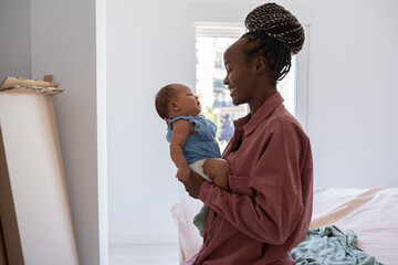 Mother holding baby in bedroom