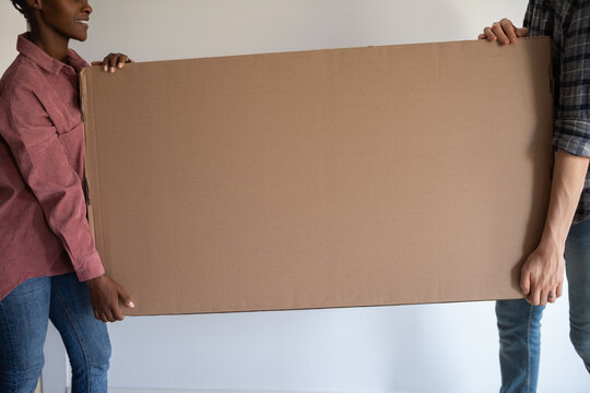 Couple carry new tv in box