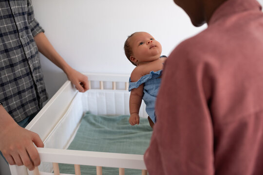 parents putting baby to cot 