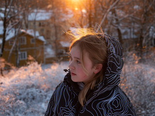 Girl looks out in wonder at snowy sunset in Finland