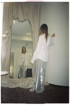 Angelical lady looking outfit in mirror before going out