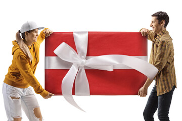 Young man and woman carrying a big wrapped present box