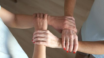 Close-up of two women's hands clasped together and forming a square or frame. The brotherhood of mankind.