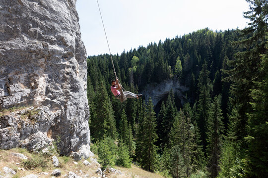Adventurer On A Self-Made Swing Near A Cliff