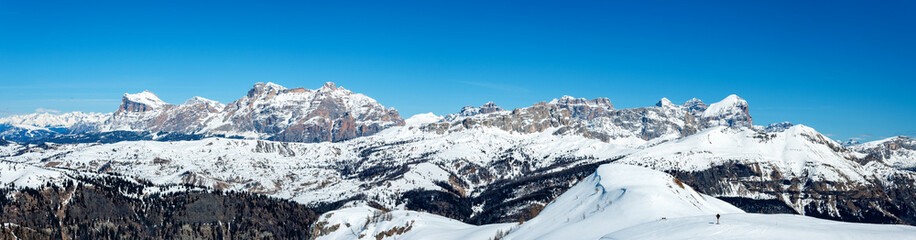 Wide winter panorama of mountain range in Italian Dolomites viewed from the slopes in Arabba ski resort