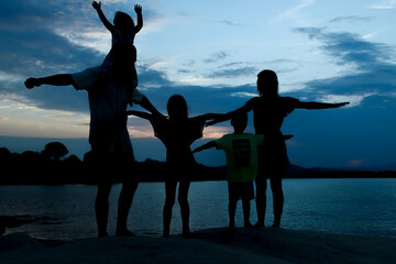 Fototapeta premium happy family by the sea on nature silhouette background