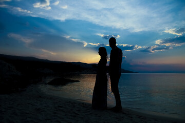 Fototapeta premium happy couple silhouette by the Greek sea on the shore background