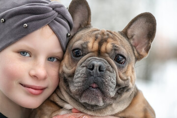 Close-up portrait of a girl with a French bulldog.