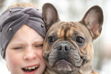 Close-up portrait of a girl with a French bulldog.