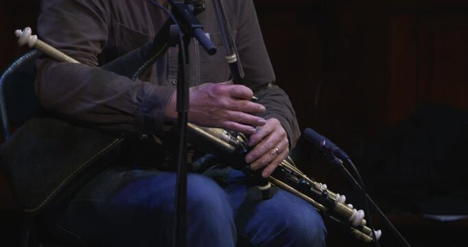 Man plays Uilleann Pipes traditional Irish music instrument Union Pipe