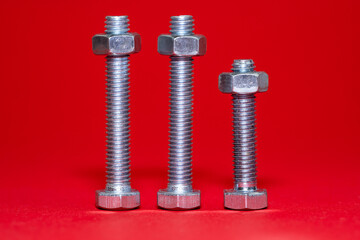 Bolts with nuts on a red background