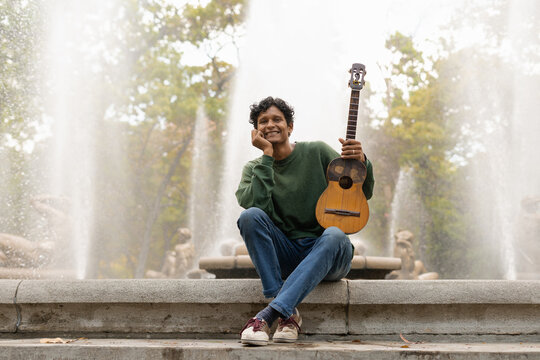 A happy guitarist smiling at the camera