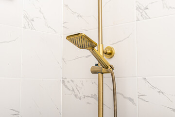 Golden plumbing in the shower. Golden shower head. Shower rod with height adjustment