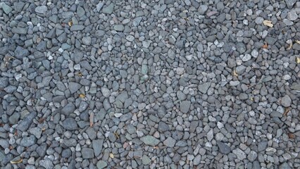 Texture of road made of small gray stones with slight camera movement.