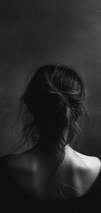 Naklejka premium Silhouette of a girl with soft lighting against a dark background, creating a minimalist and dramatic atmosphere