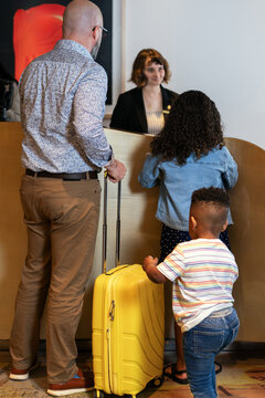 Family Checking In at Hotel Reception