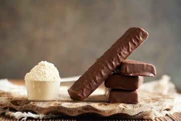 Healthy vegetarian protein chocolate bars with a scoop of whey protein powder