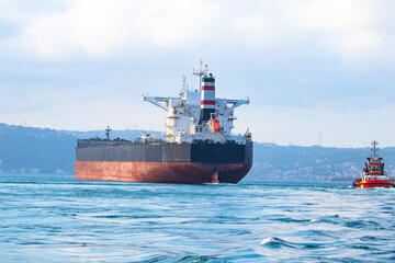 Fototapeta premium Ships carrying dangerous goods. Oil tanker and tugboat passing through the Bosphorus. No people, nobody.