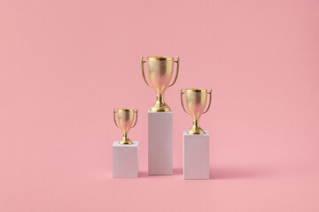 Three different podiums with shiny goblets on tops
