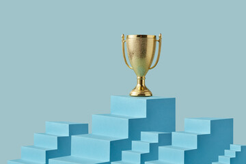 Champion cup on highest step of staircase in blue studio