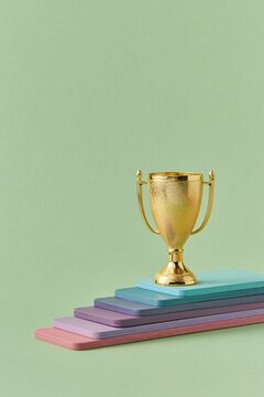 Golden winner goblet standing on multilayered platform 