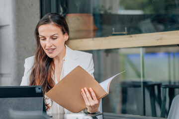 business woman with laptop on the terrace reviewing documents