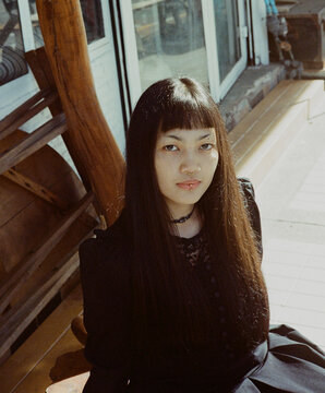 Young woman wearing black costume, gothic metal theme. Film photo