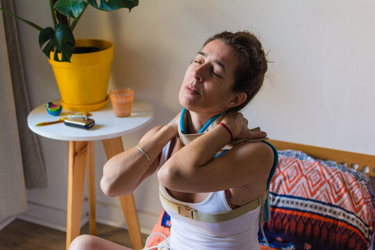 Self-care pleasure: latina woman relaxing with heating pad