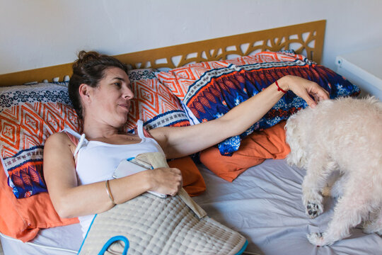Woman with the flu is in bed with her dog