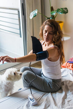 Woman using blood pressure monitor