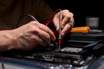 Hands Engaged in Working with Various Electronic Components and Multimeter Testing Processes