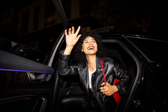 Woman Waves To Friends While Exiting Car 